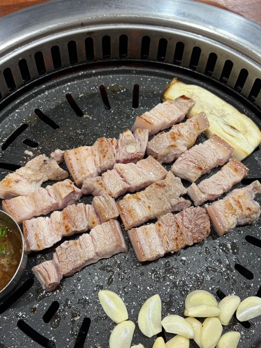 불판 위에서 구워지는 오겹살과 마늘