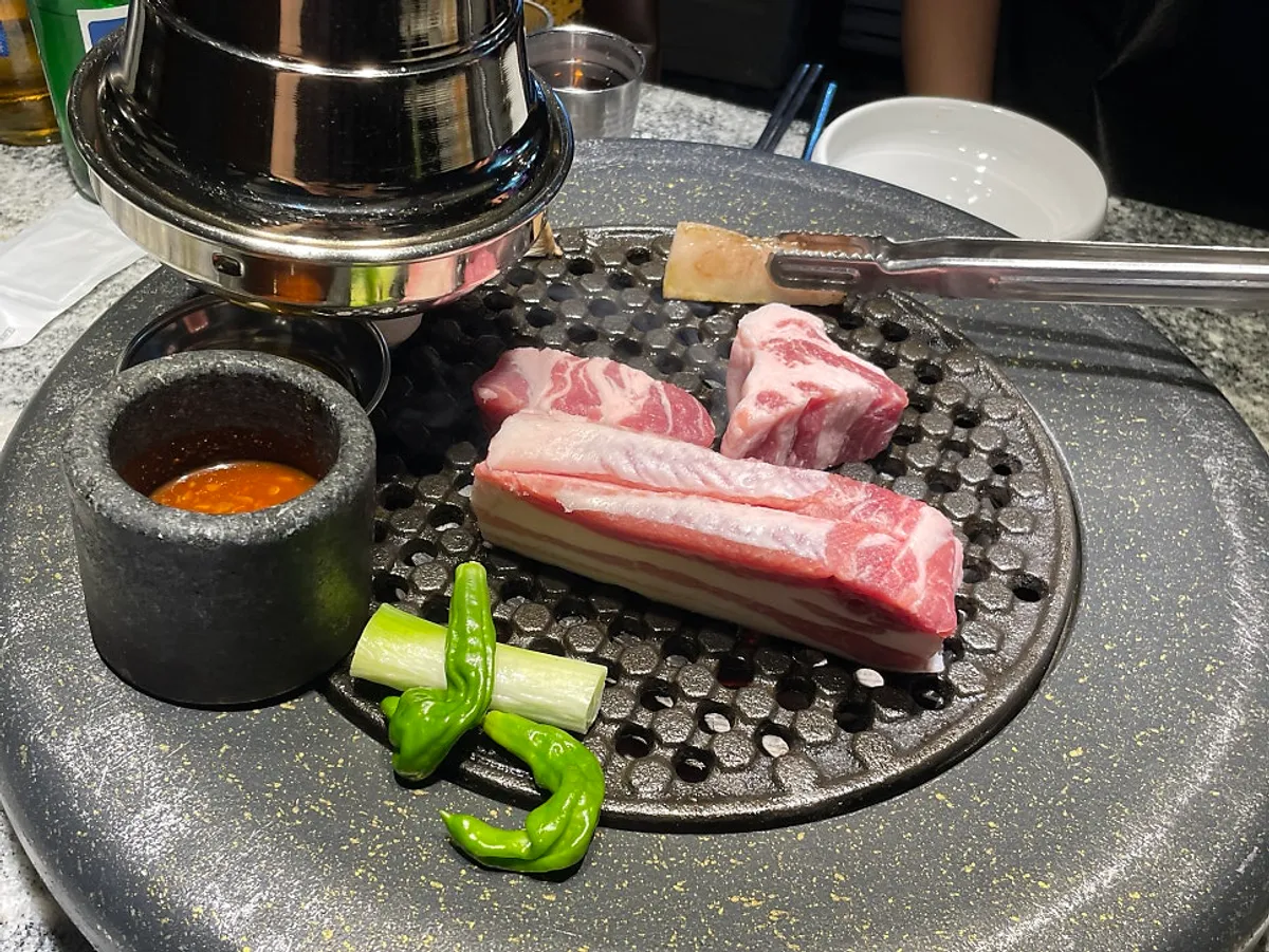 Aged pork belly placed on the charcoal grill