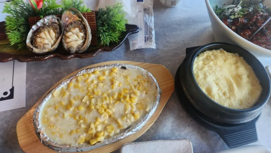 전복구이 콘치즈 계란찜이 놓인 테이블