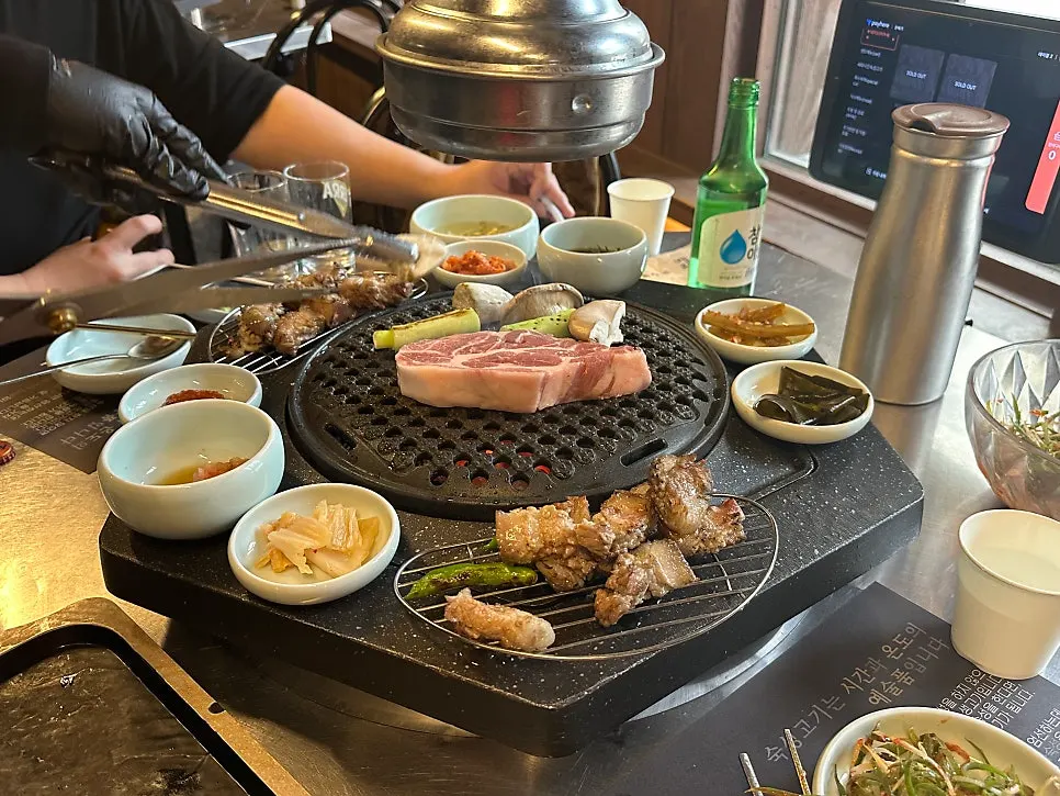 A piece of pork belly with ssam and side dishes
