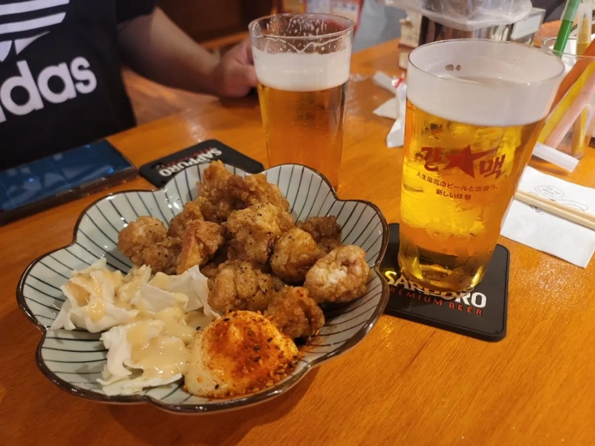 Mesa servida con cerveza Sapporo y Osaka chicken