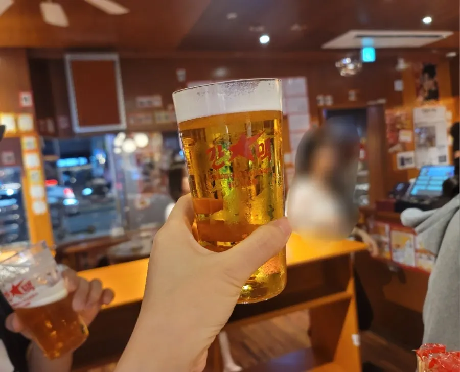Espuma de la cerveza Sapporo en el vaso fino