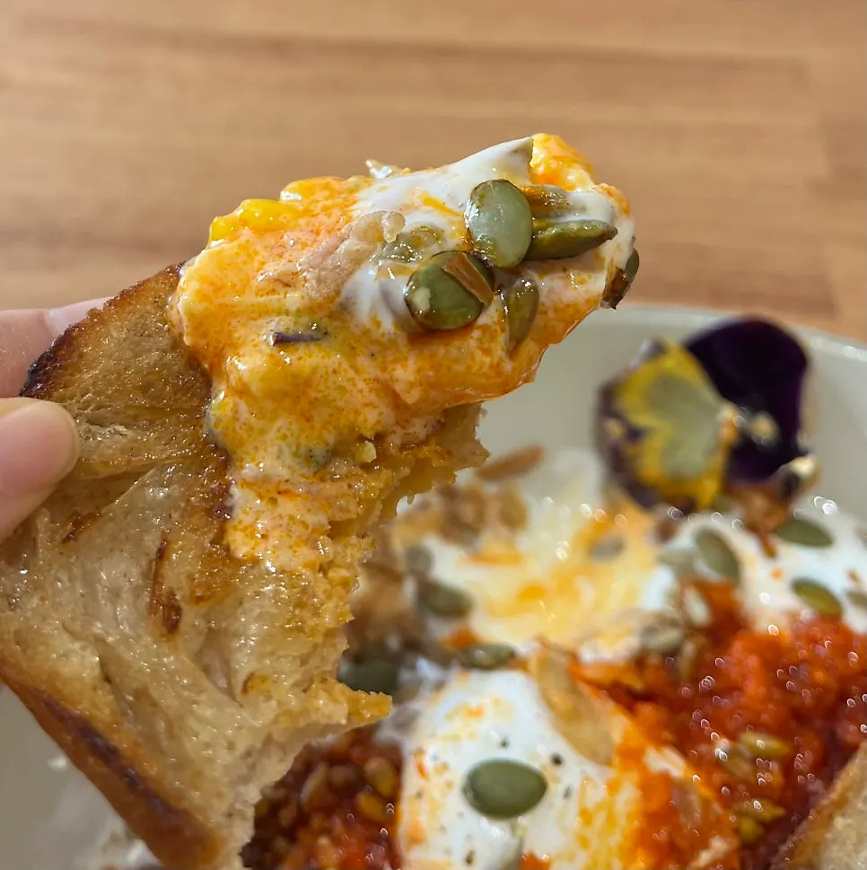 Close-up of Garlic Butter Eggs with the poached egg broken open