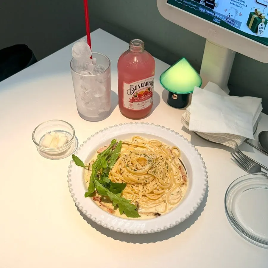 Table set with the ordered truffle cream pasta and drink