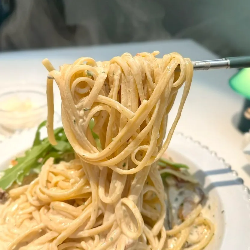 A bite of pasta coated in thick cream sauce
