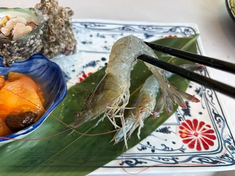 Plate of marinated crab, raw shrimp, and abalone sashimi