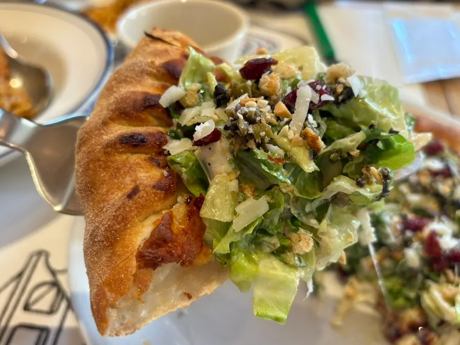 Salad pizza showing nuts and cranberries