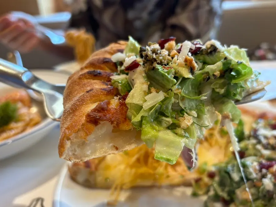 Slice of salad pizza being lifted up