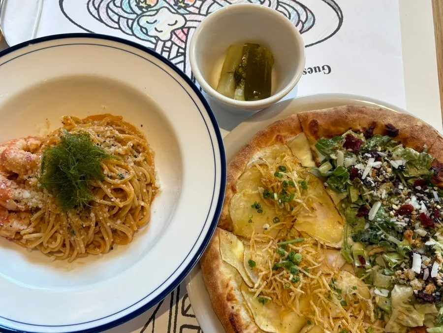 Table spread of pizza and pasta at the end of the meal