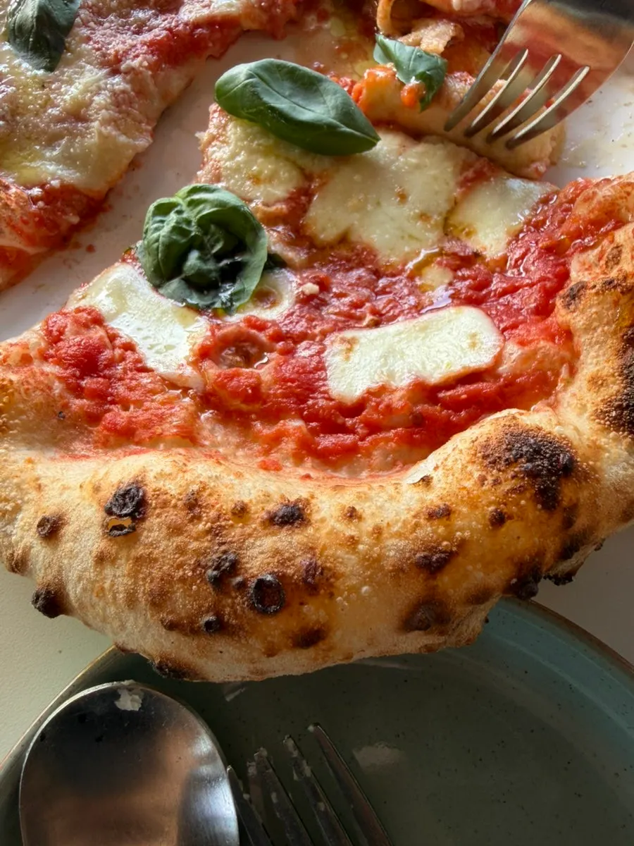 Margherita wood-fired pizza and cuttlefish aglio olio pasta on the table