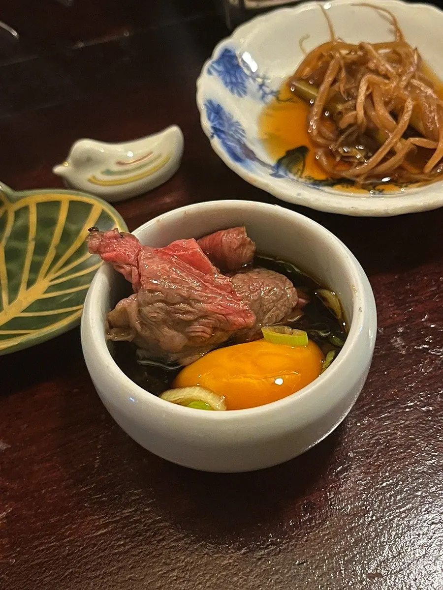 노른자 소스에 고기를 찍는 모습