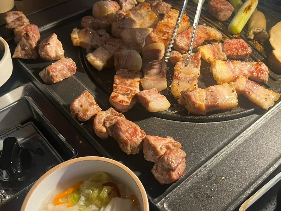 Grilled meat kept warm beside the pan