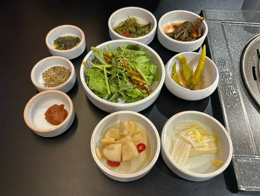 Table setting with pickles, anchovy salt, and chimichurri