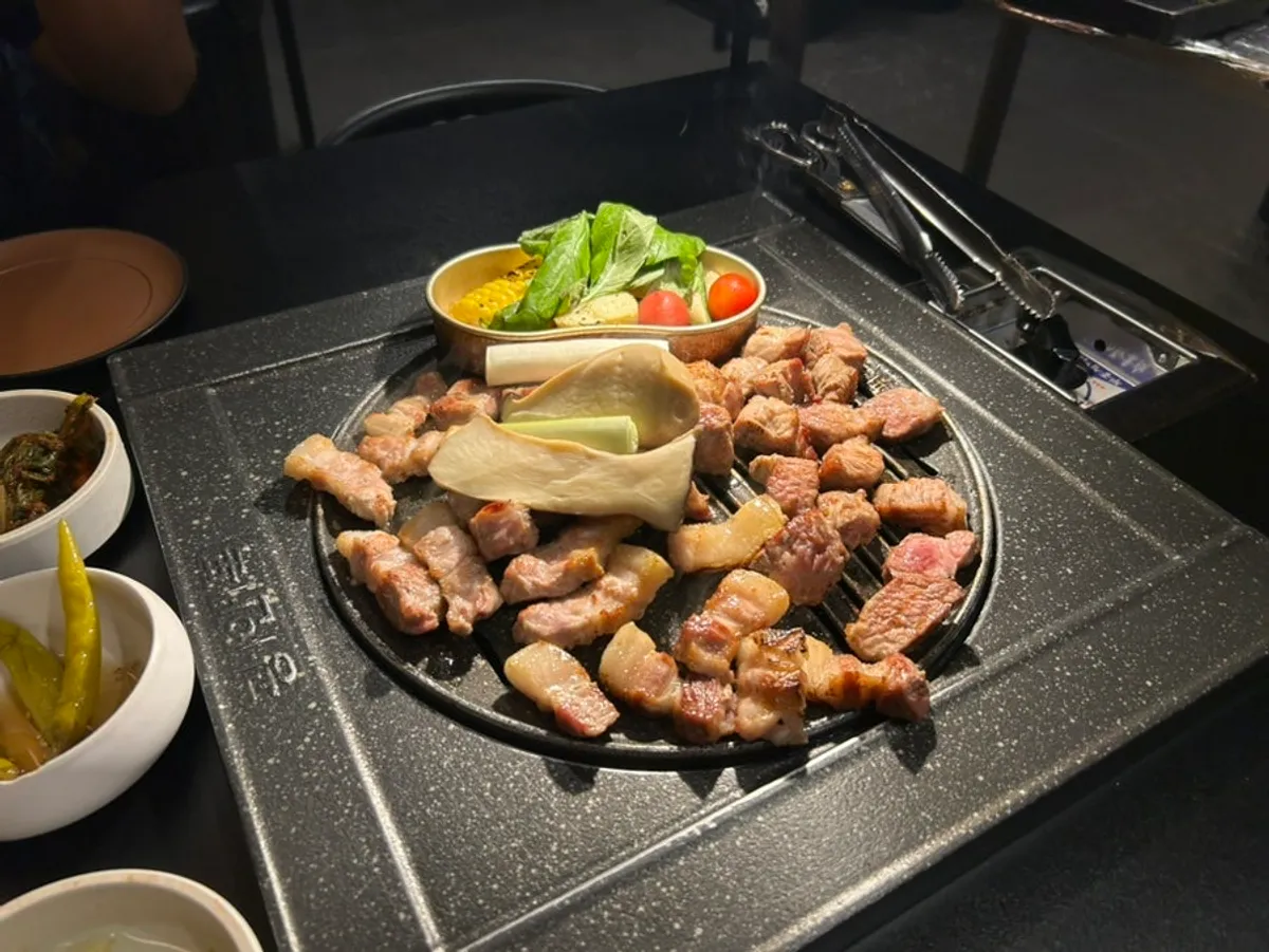 Pre-seared aged pork being grilled again on the tabletop grill