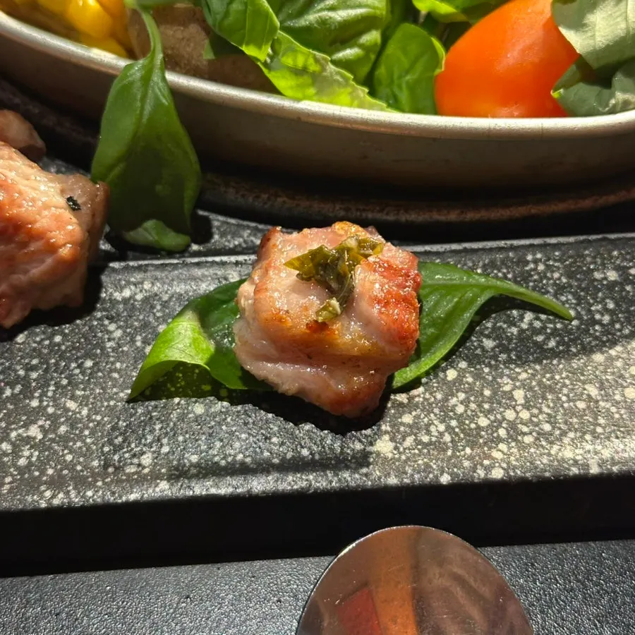 Pork neck and pork belly on the grill, cooked and served by staff