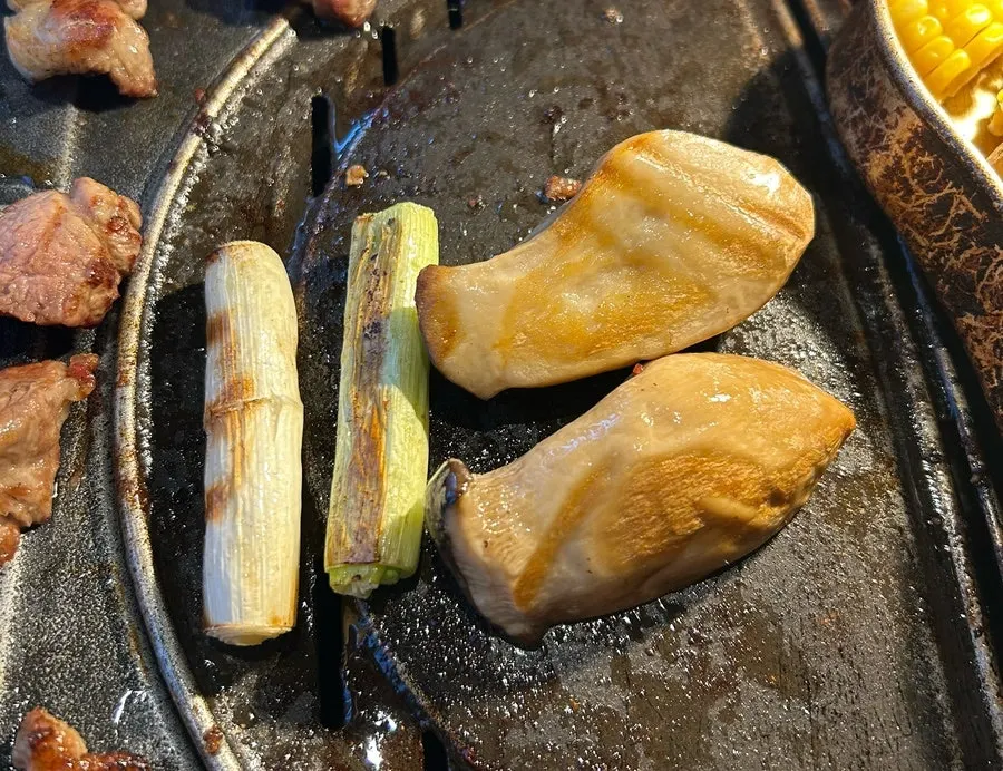 Mushrooms and scallions grilled alongside the meat
