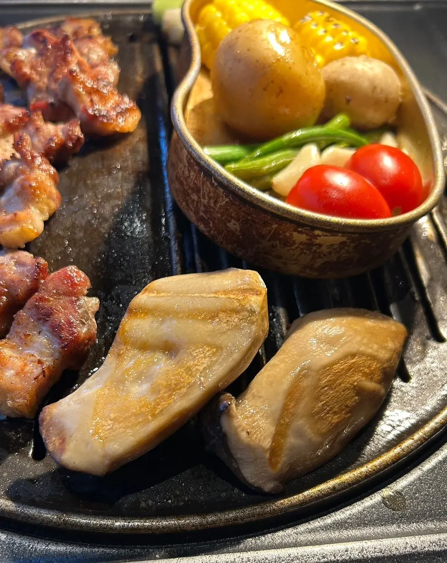 Meat and side vegetables cooking to a golden finish