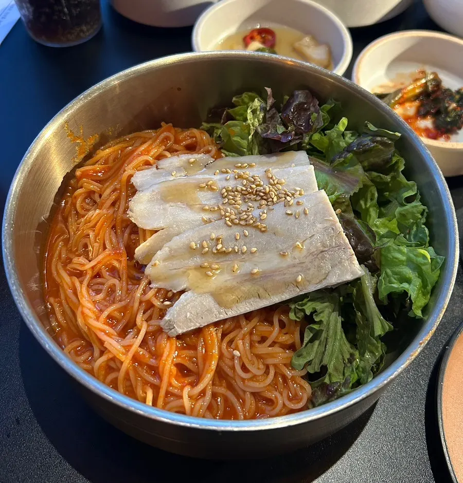 Gwang-anmok bibim noodles topped with cold pork