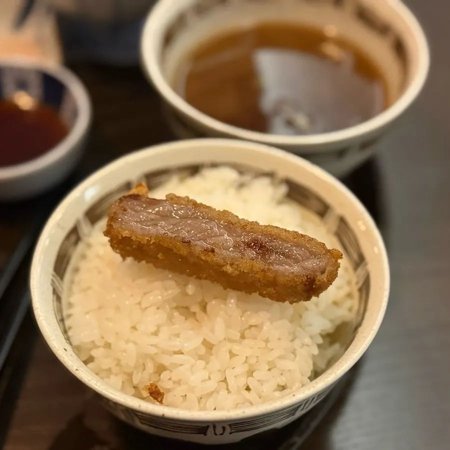 A piece of gyukatsu dipped in sauce