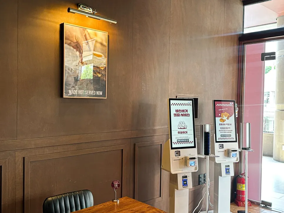 Interior of Base Burger Gwanggyo with neon lighting and wood furniture