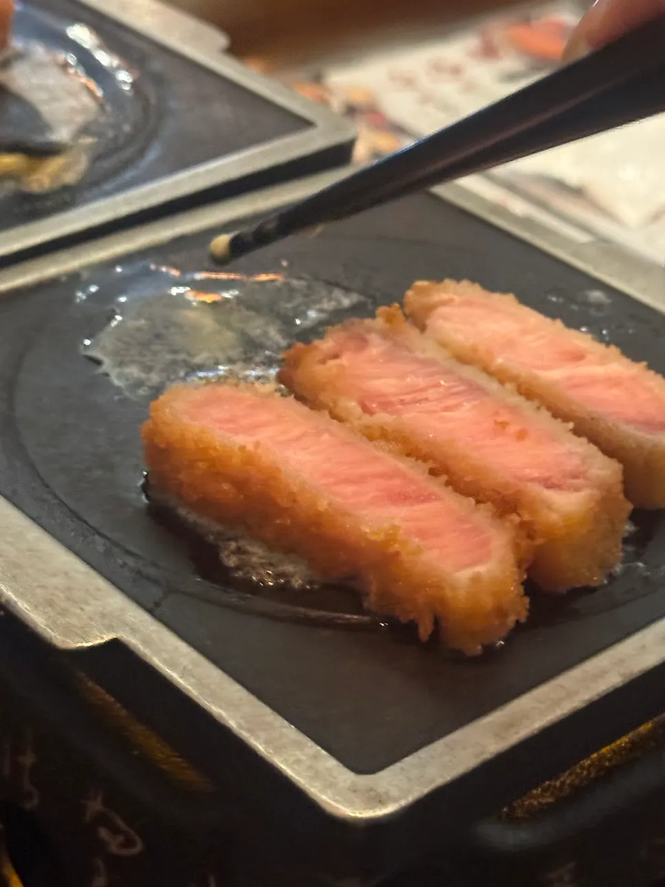A piece of gyukatsu placed on the butter-melted grill