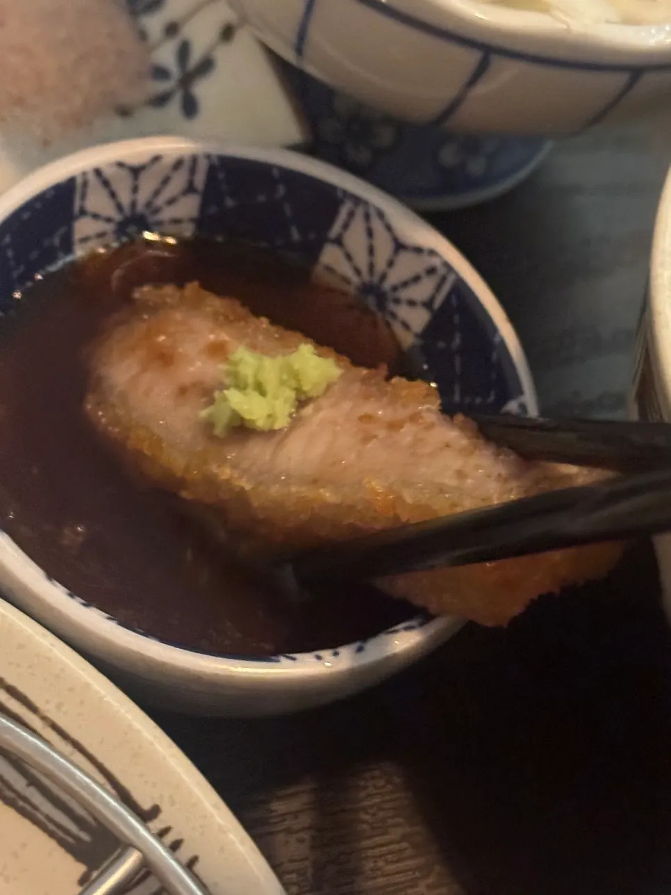 A piece of gyukatsu about to be dipped in salt
