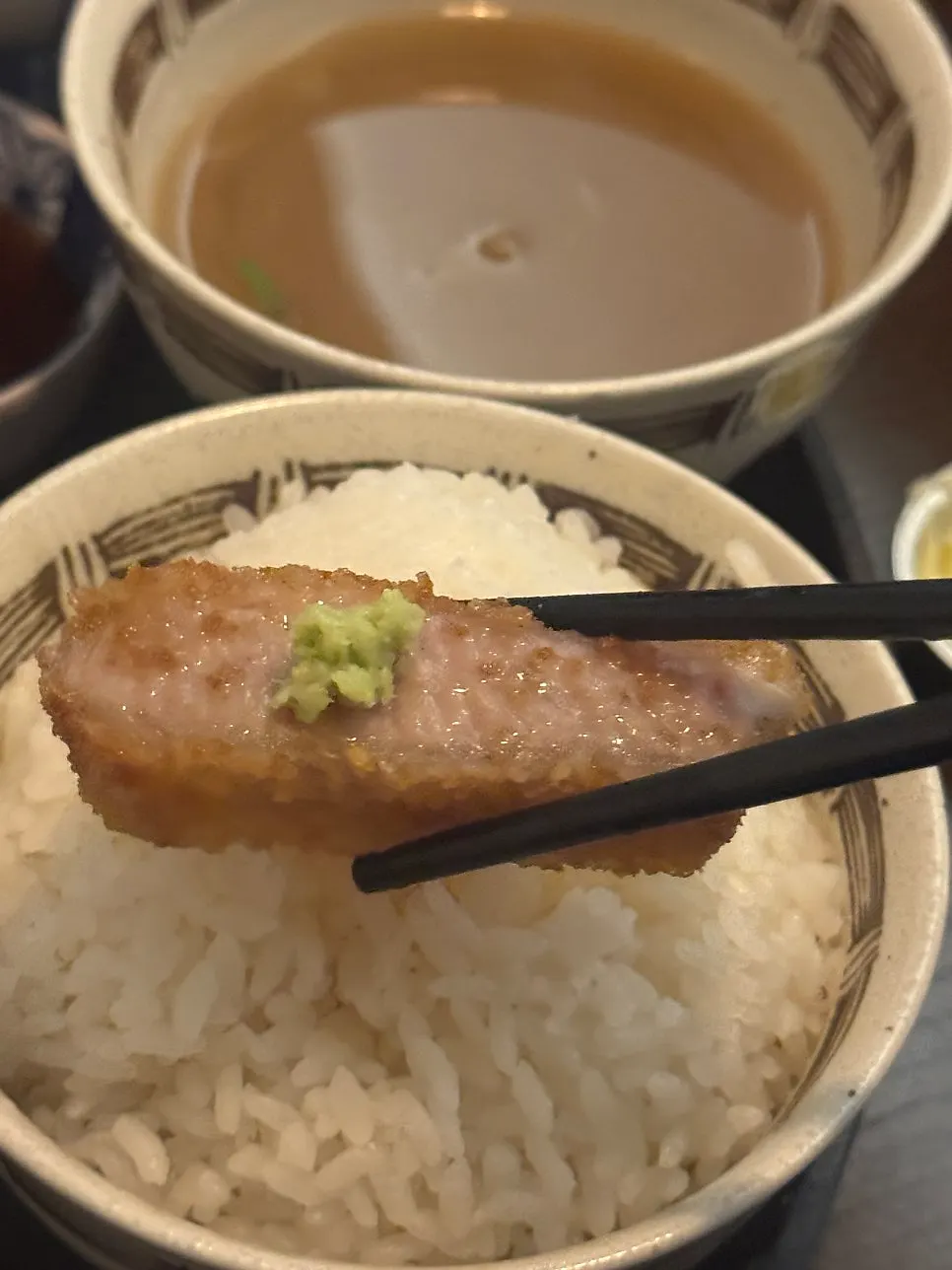 Gyukatsu dipped in sauce with a bowl of rice
