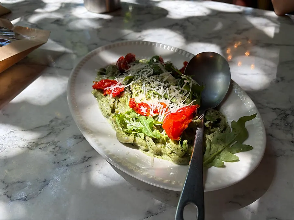 A plate of basil cream conchiglie burrata