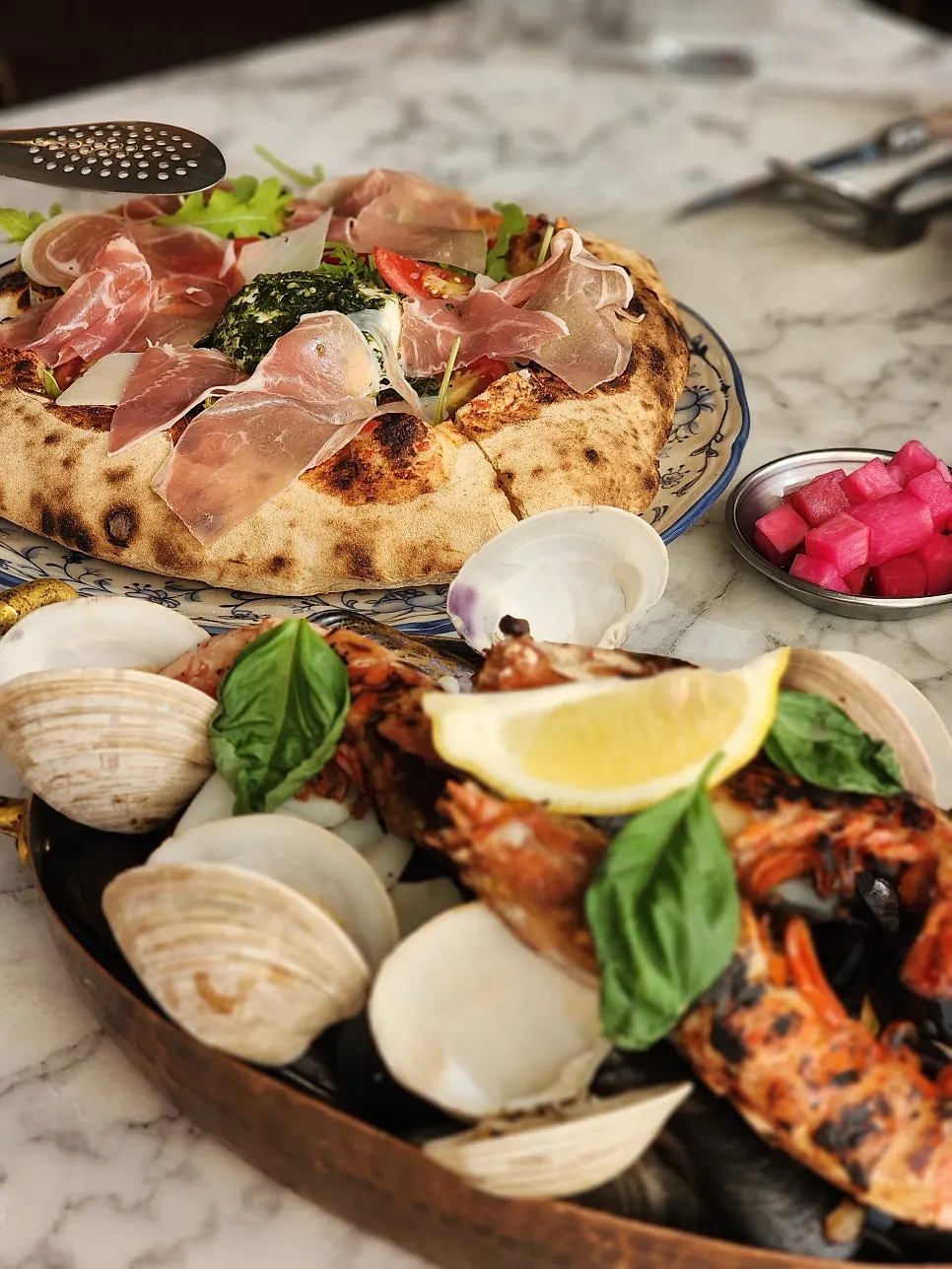Wood-fired pizza topped with ham and rocket