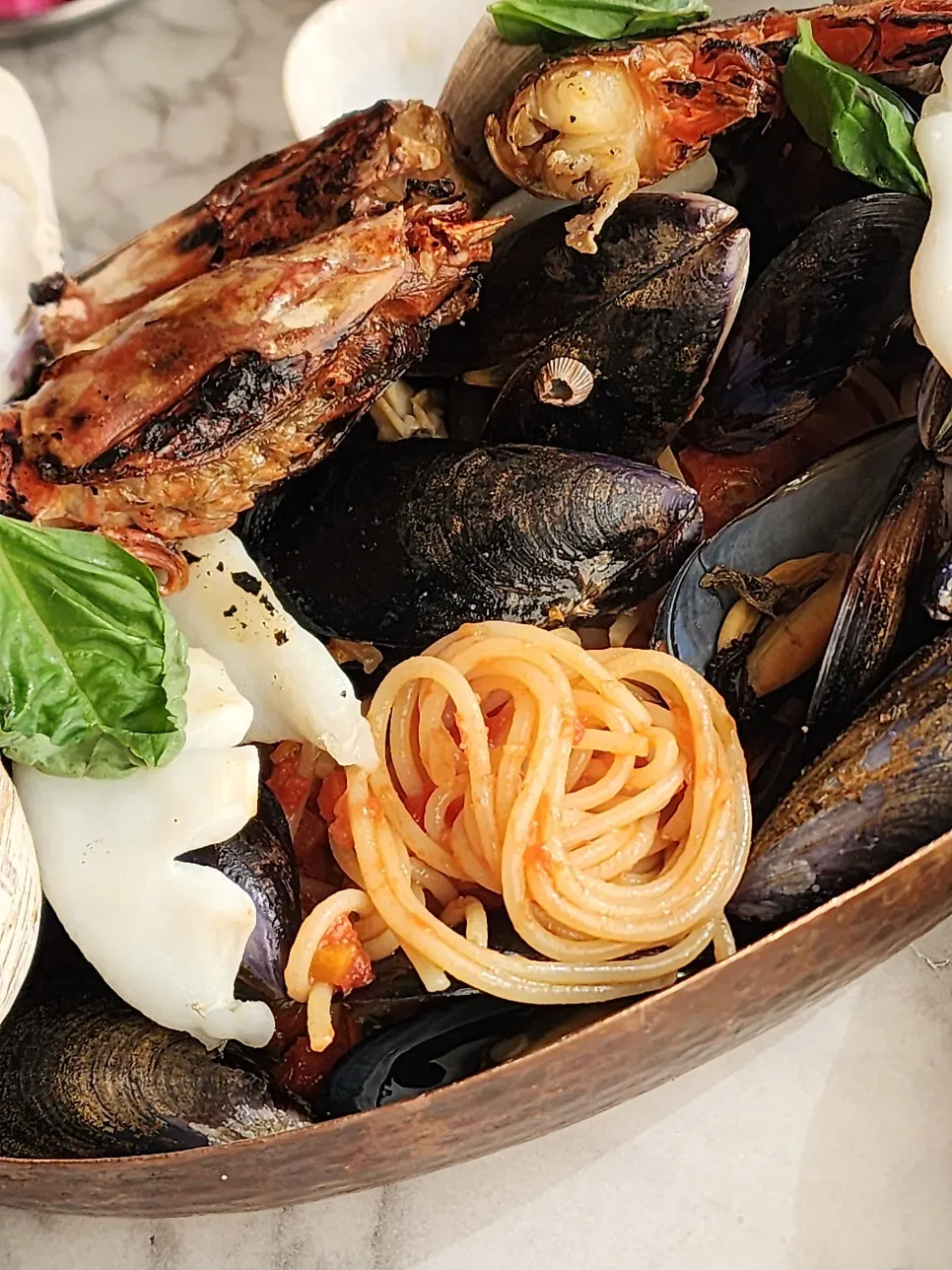 Pasta noodles revealed underneath the seafood