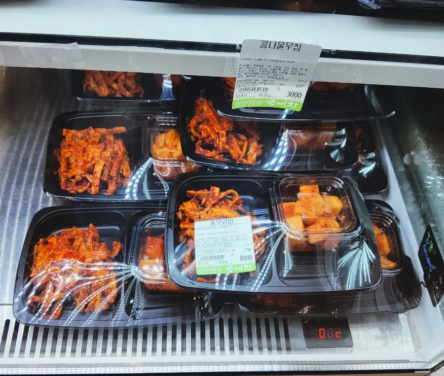 Refrigerated display case with a wide variety of side dishes at Gukaechan