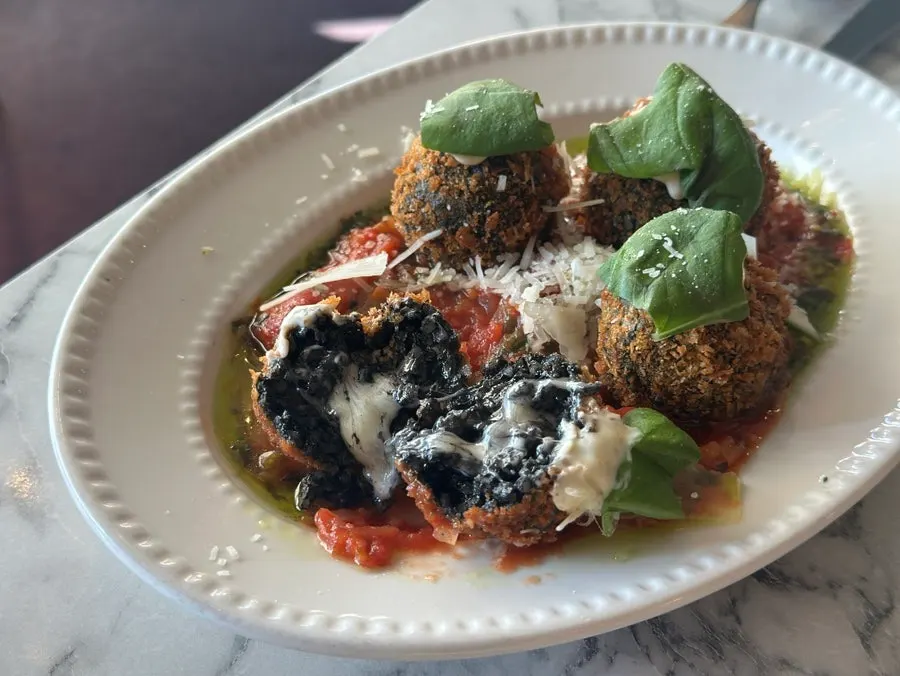 A bite taken out of the squid ink arancini