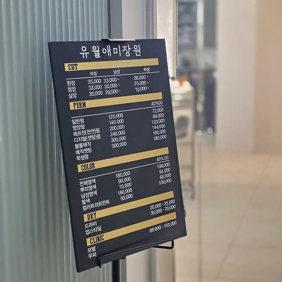 Price list for cuts, perms and colors by staff level posted at the entrance