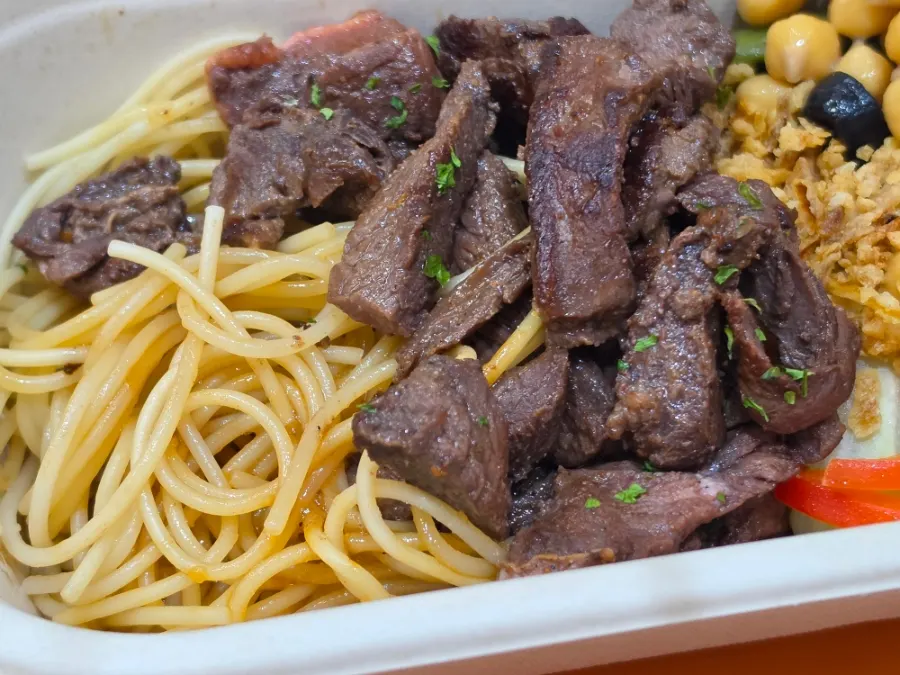 Balsamic-sauced pasta noodles found underneath the beef