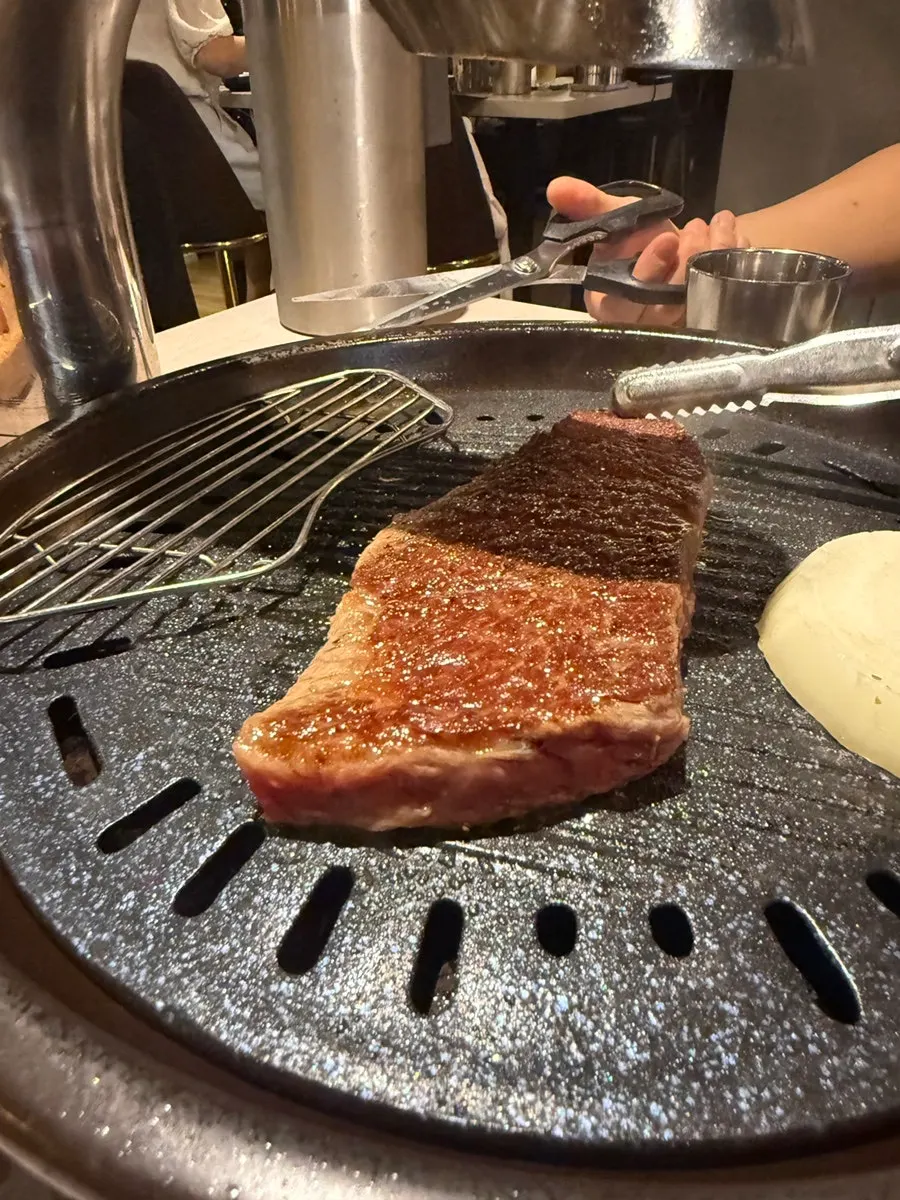 A staff member grilling the black beef sirloin