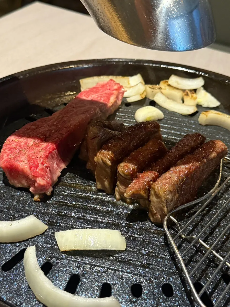 Cooked meat moved to the side of the grill
