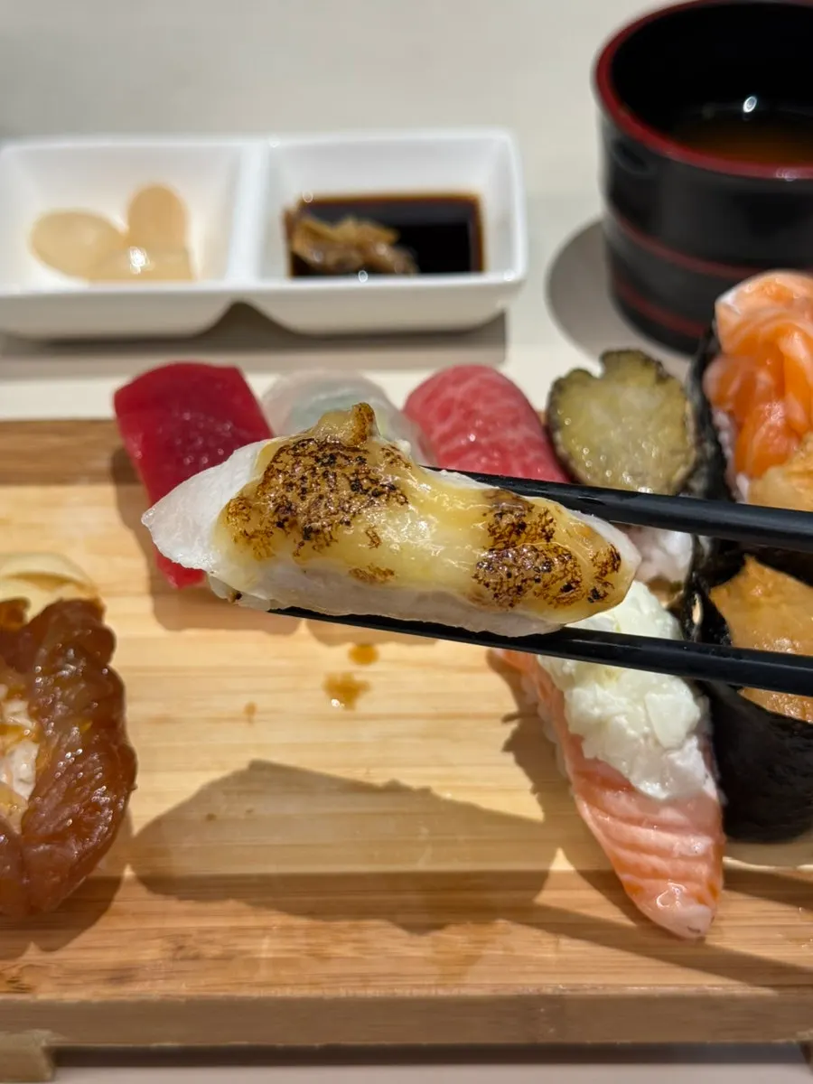 Swordfish sushi topped with cheese sauce