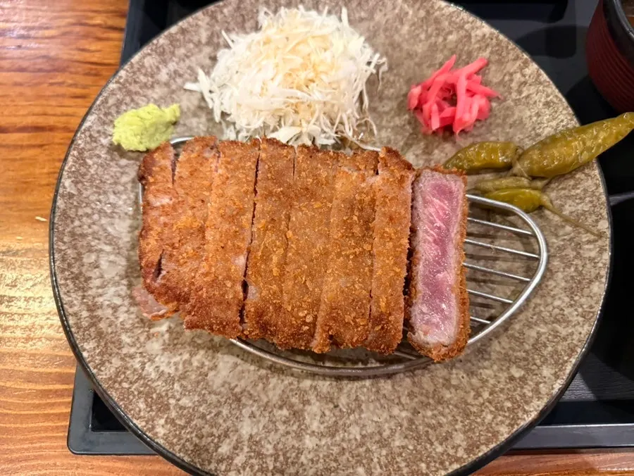 A piece of gyukatsu being grilled on the fire