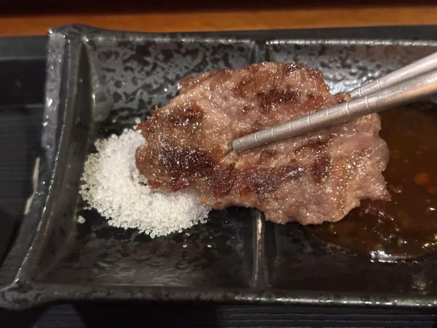 A piece of gyukatsu topped with wasabi and ginger