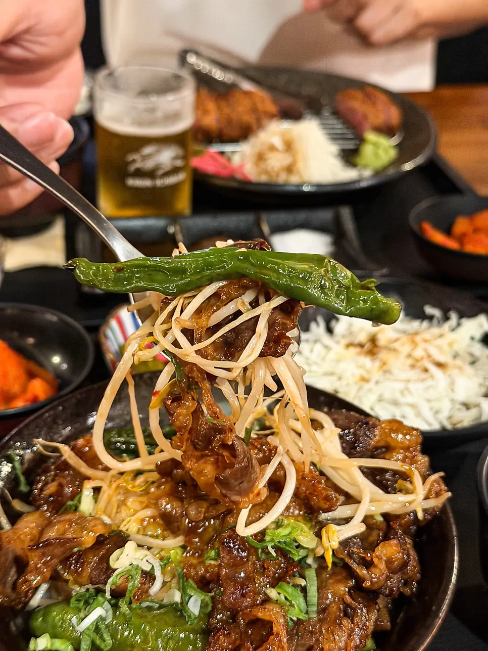 A bite of beef belly rice bowl with the yolk broken