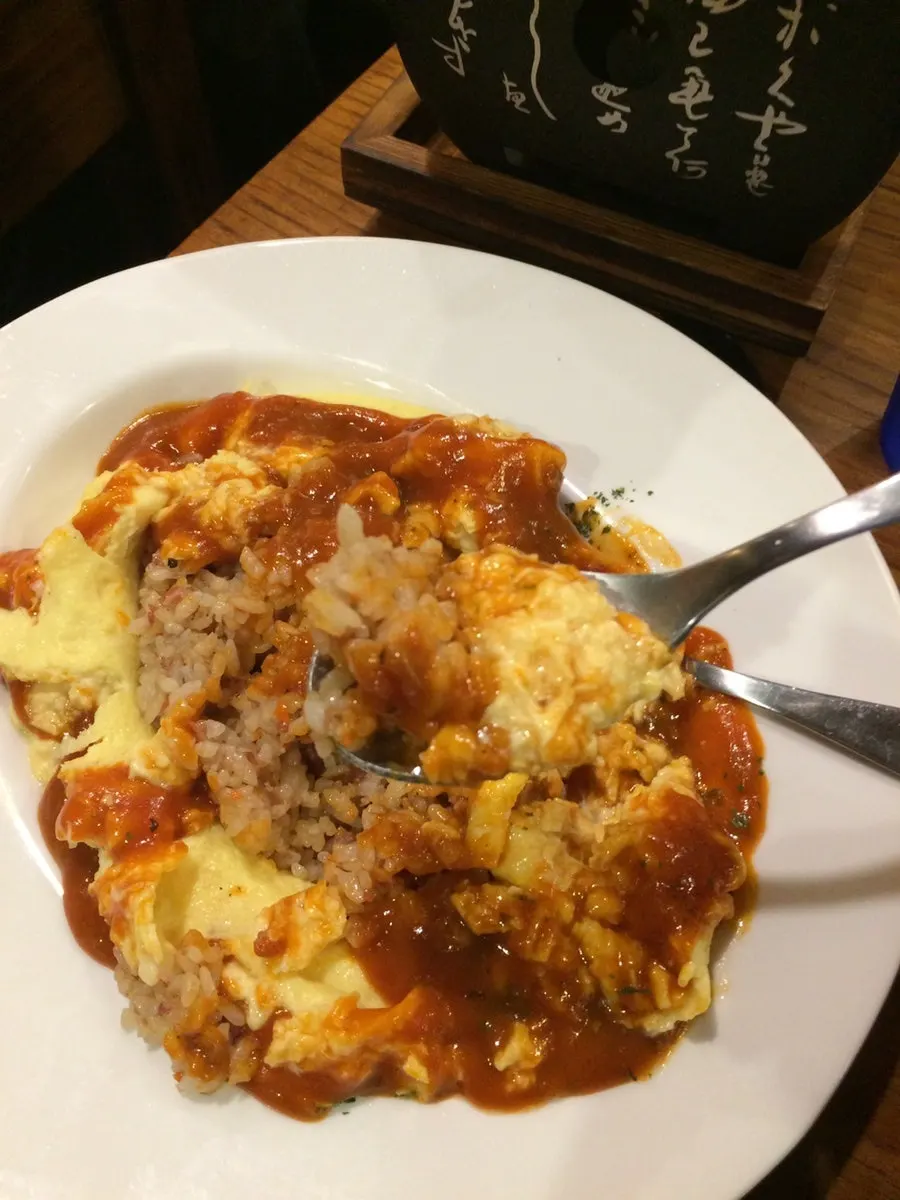 A spoonful of omurice with egg and rice lightly mixed
