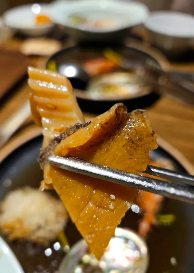 A spoonful of plump abalone lifted up