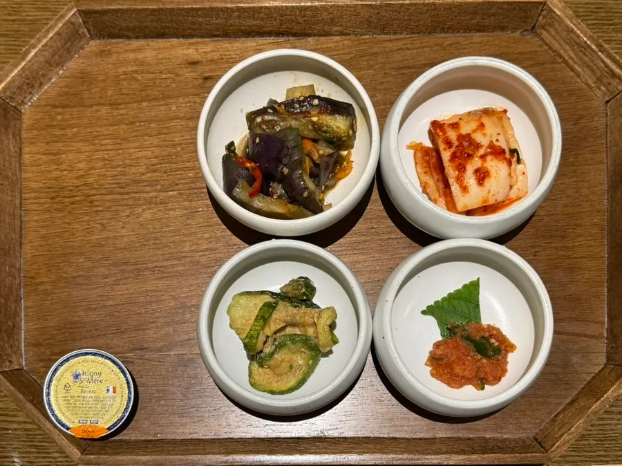 Main course table with kimchi, salted pollack roe, stir-fried eggplant and zucchini side dishes