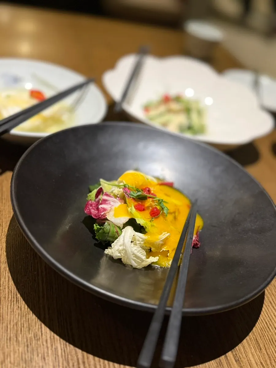Table setting with seasonal porridge, white kimchi, and two salads