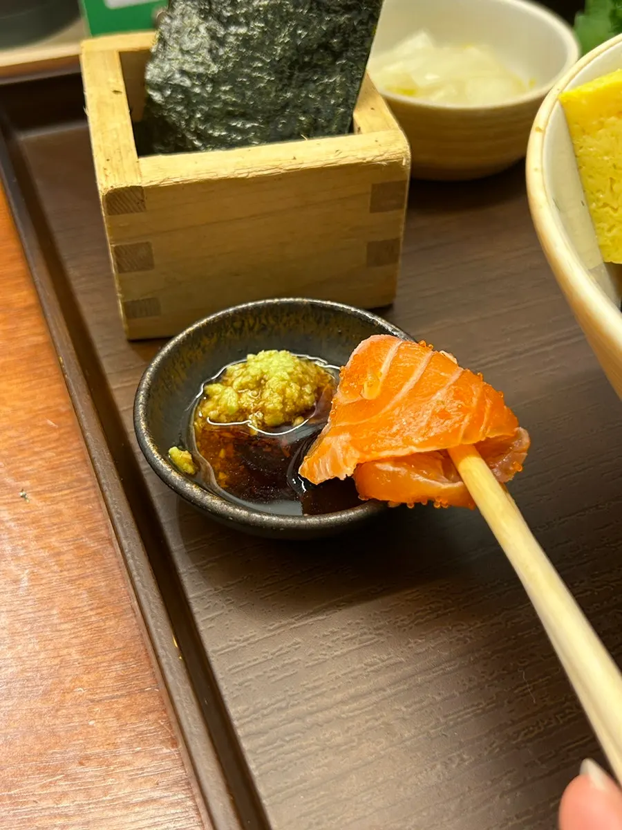 A bite of sashimi placed on gim