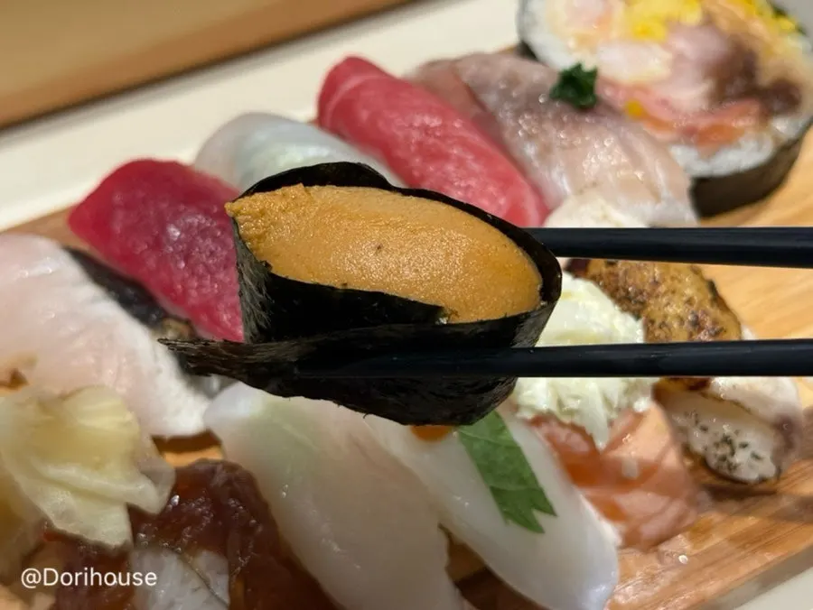 Engawa sushi topped with chopped green onion