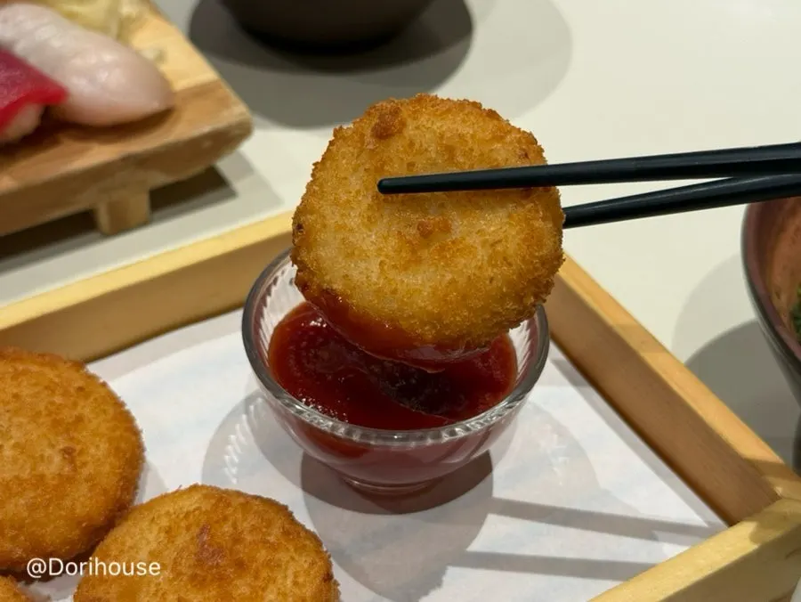 Cross-section of a potato croquette dipped in ketchup