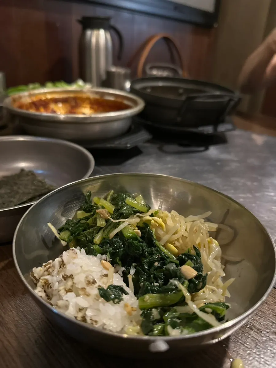Side dishes including bean sprouts, young cabbage, radish greens, braised perilla leaves