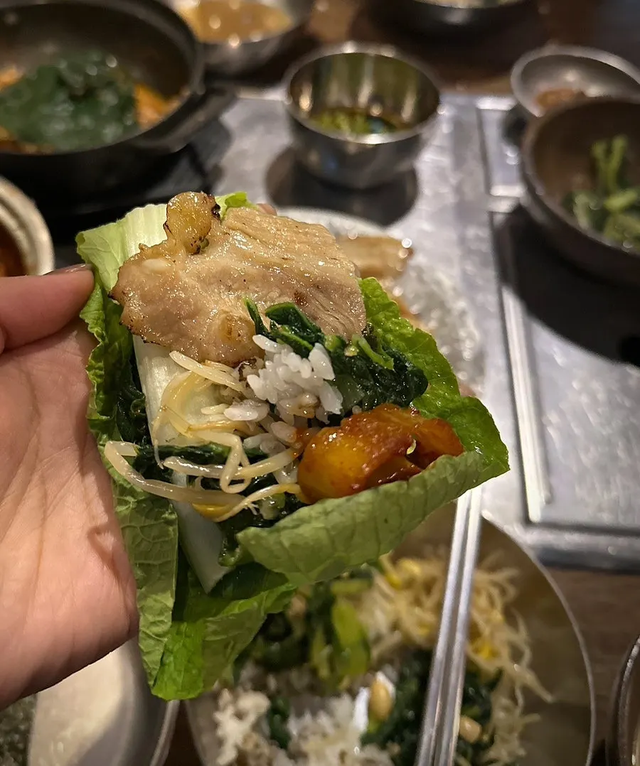Lettuce wrap topped with rice, charcoal bulgogi, and doenjang stew