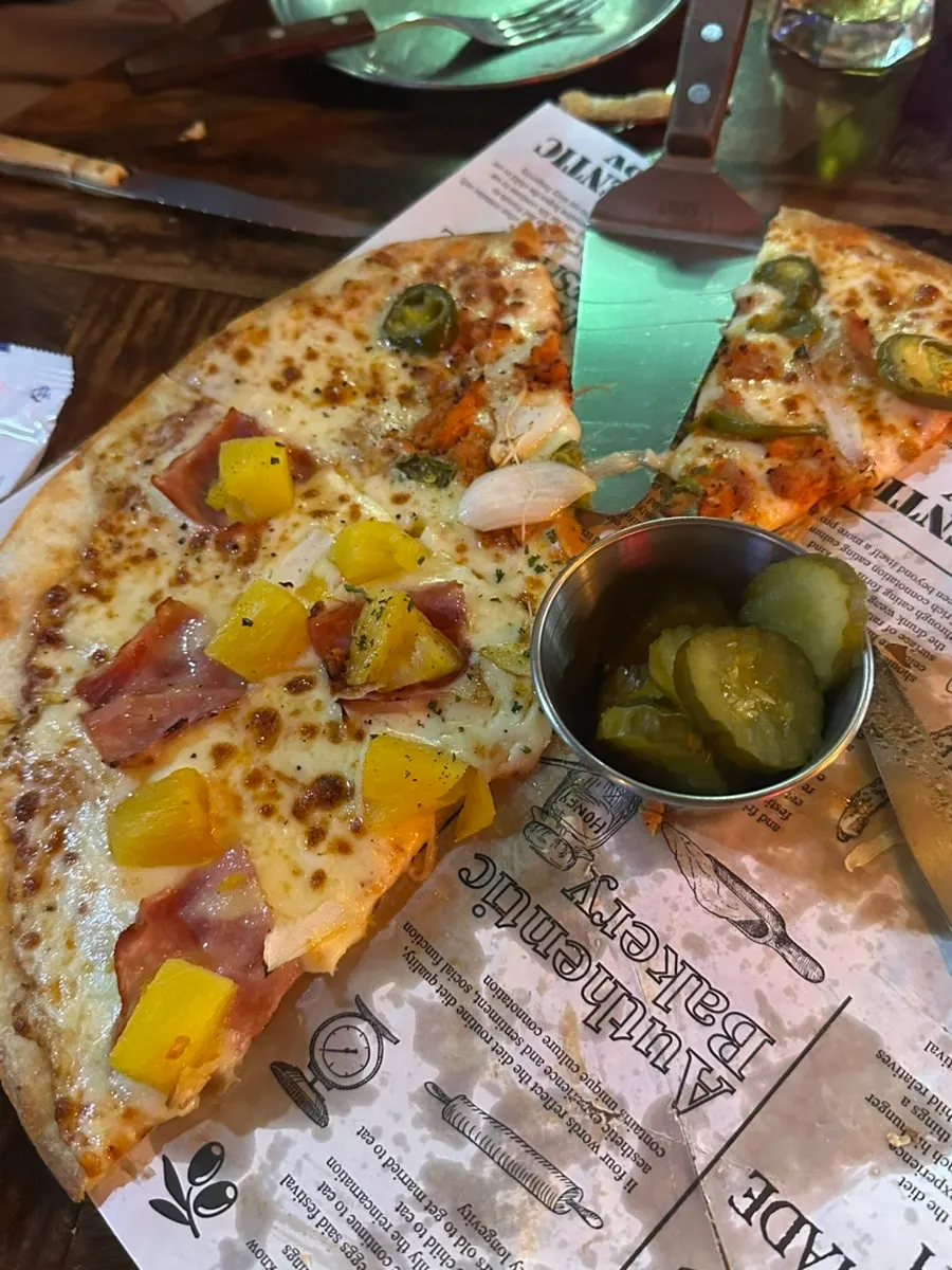 Gelas draft bir yang disajikan bersama pizza